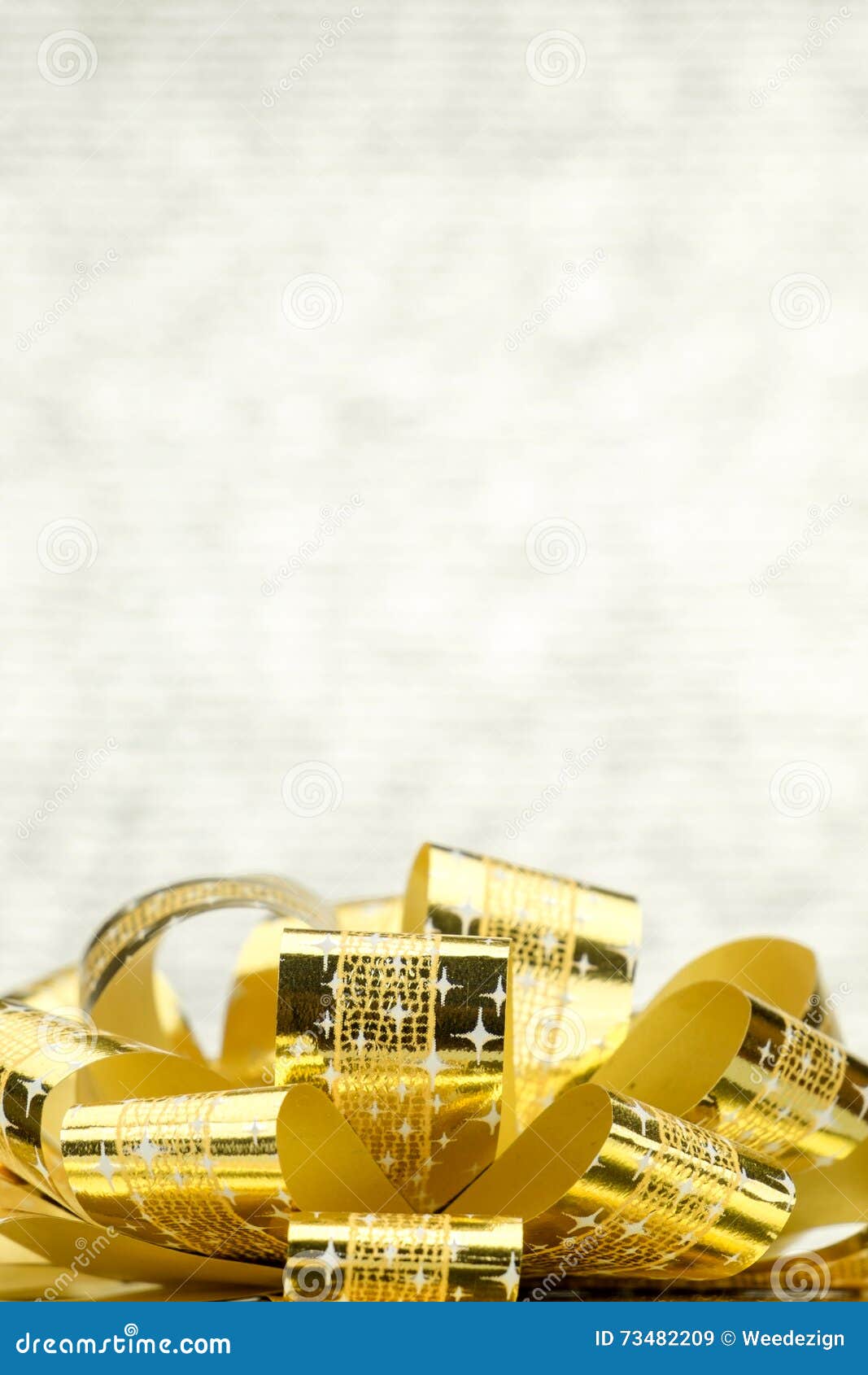 close up golden present box with big bow at bokeh white blur background, leave space on top to adding your content